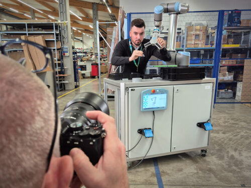 Fotograf shootet einen Kollegen am Cobot-Tisch