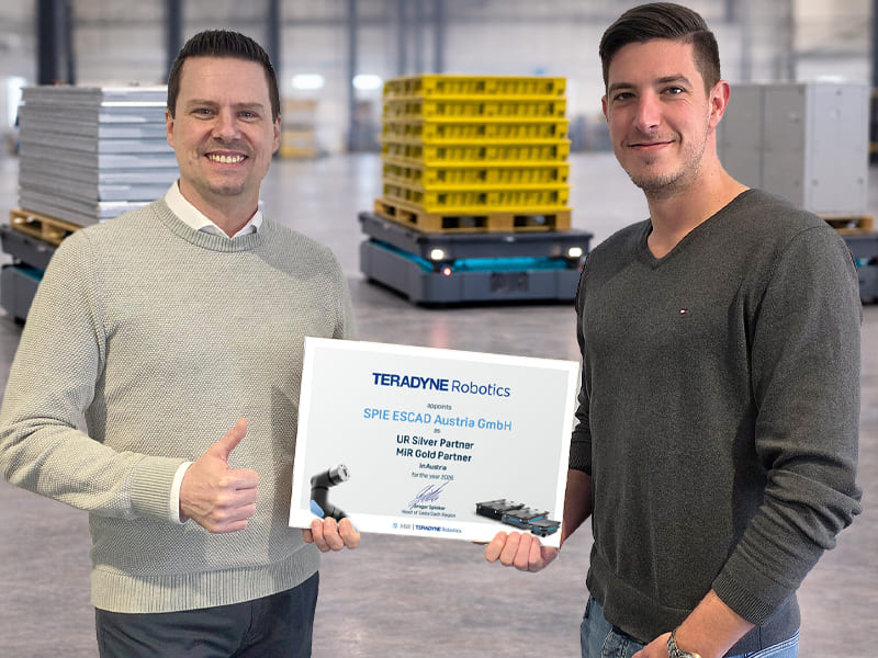 Zwei Robotikexperten präsentieren das Partnerzertifikat von MiR und UR