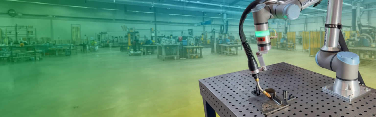 Zu sehen ist die UR12e Schweißanlage. Im Hintergrund ist eine Schweißhalle zu sehen.