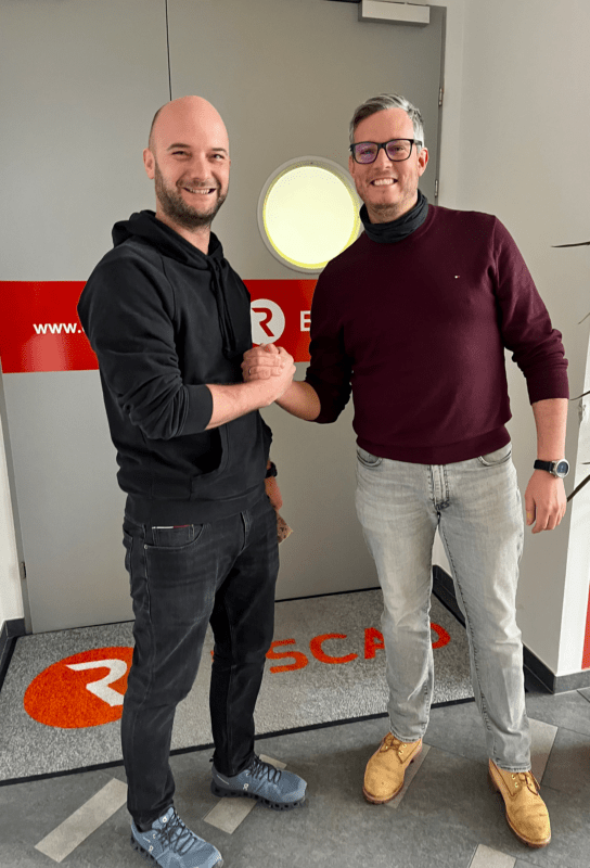 Zwei Männer die sich die Hand geben einer von ihnen feiert sein 5 Jähriges Jubiläum.